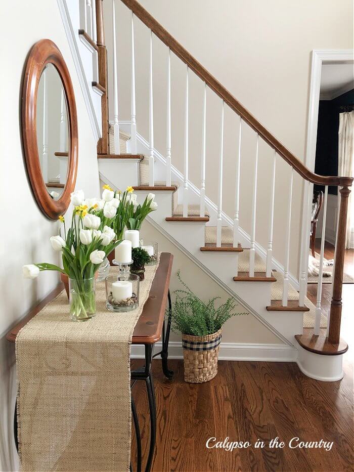 Calypso in the Country - Traditional-staircase-with-white-spindles-and-foyer-table-decorated-for-spring