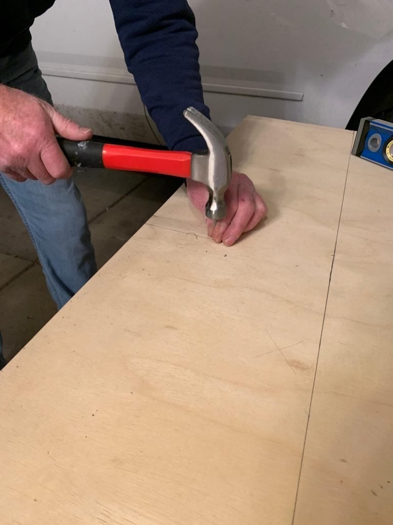 hammering a nail at the middle to create the pivot points for the DIY archway