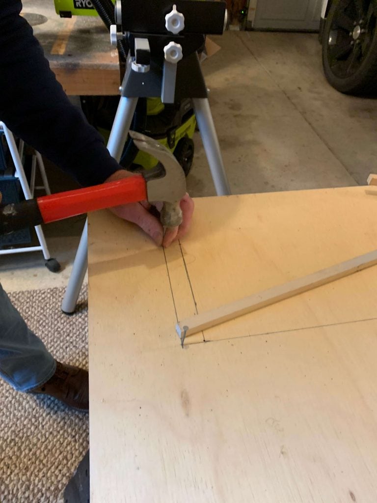 hammering a nail at the corner to create the pivot points for the DIY archway