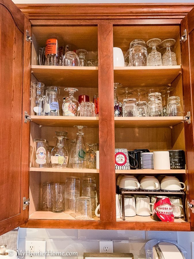 How to organize your kitchen cabinets using clear and simple strategies to tackle kitchen cabinet dysfunction without losing your mind. This is the before photo of the massive amount of cups we had in one cabinet.