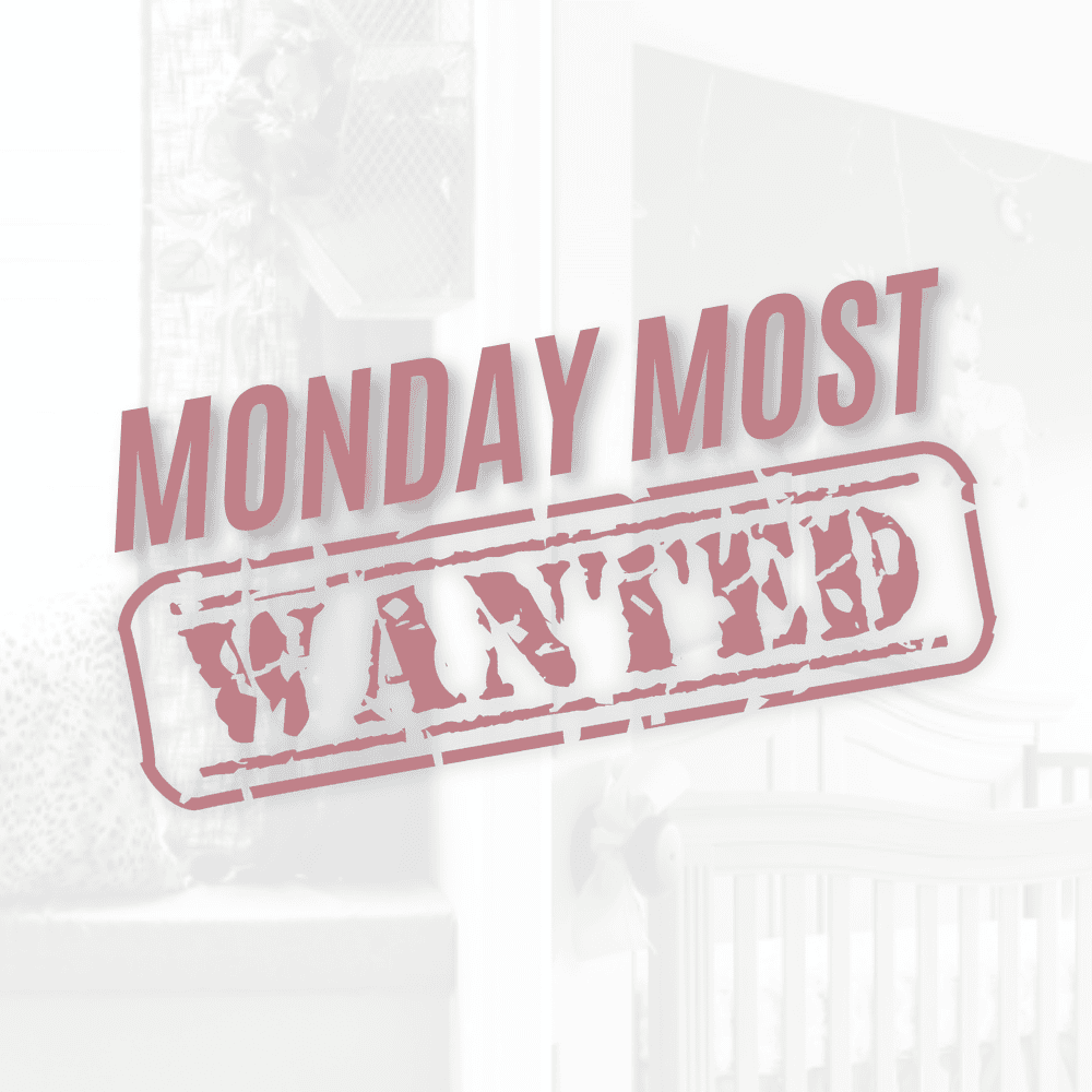 Pink text reads "YAY MONDAY MOST" above a red stamp-style font saying "WANTED." In the background, a blurred image of a crib and decor adds an air of mystery to the scene.