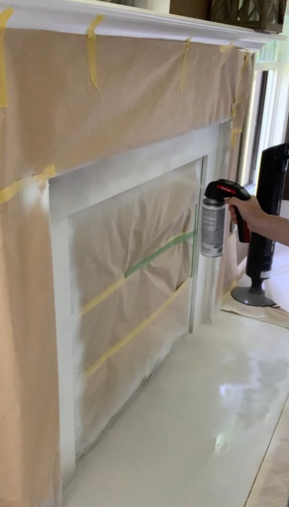 Spray painting the fireplace surround with chalk spray paint