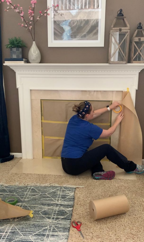 prepping with brown paper to spray paint fireplace surround
