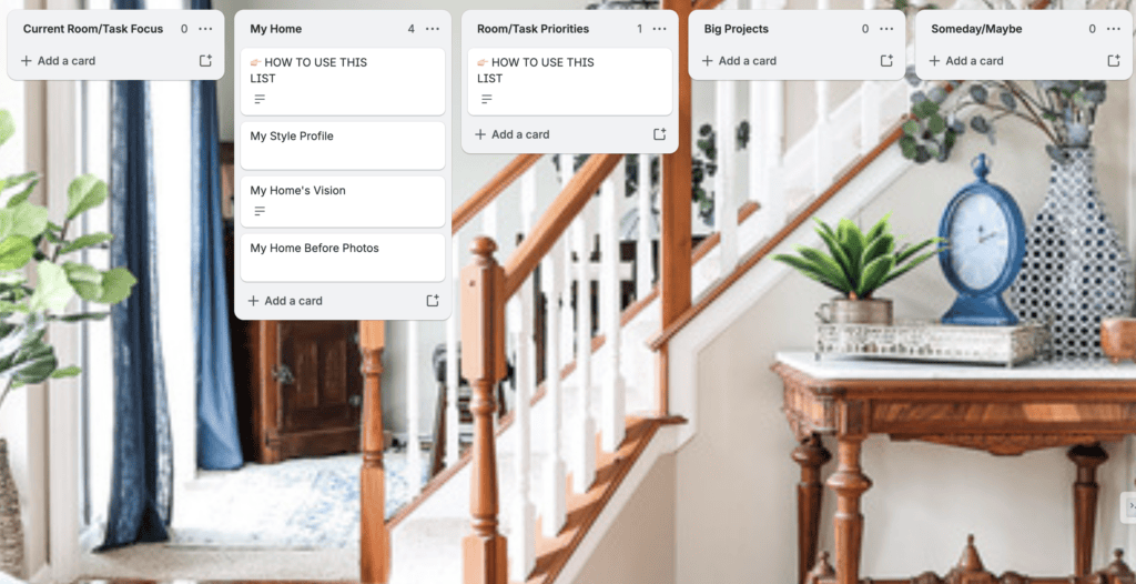 A digital task board is displayed in front of a staircase and entryway, perfect for those looking to organize home goals with columns and cards for each category.