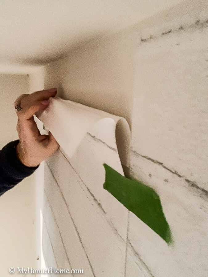 Fold the backing under to attach the peel and stick wallpaper to the wall.